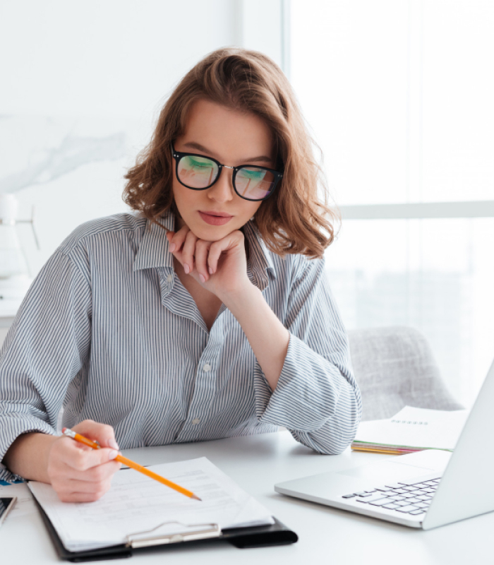 joven-empresaria-concentrada-gafas-camisa-rayas-trabajando-papeles-casa 1